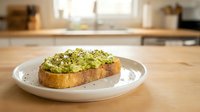 Avocado toast with seeds on sourdough bread served on white plate in modern kitchen. Healthy breakfast meal with green spread and nutritious toppings.
