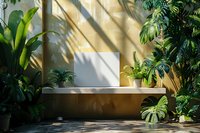Tropical plants and shadows on yellow wall with white empty frame, creating modern minimalist garden composition perfect for interior design and urban jungle aesthetics.