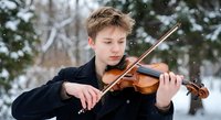 Young Caucasian teenage boy playing violin outdoors in snowy winter park, focused expression, snowflakes falling, classical music performance.