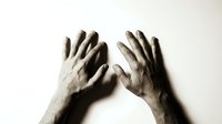 Dirty muddy hands pressed against glass surface showing desperation and struggle in dramatic sepia tone lighting for emotional storytelling concepts.