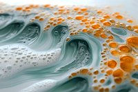 Swirling turquoise waves merge with orange bubbles creating dynamic fluid art pattern. Abstract macro photography captures mesmerizing flow of paint and liquid textures.