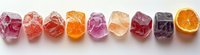 Colorful fruit jelly candies arranged in a row with orange slice, showcasing vibrant translucent textures and sweet dessert variety.