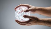 Male hands protecting glowing geometric sphere with network connections representing digital technology, data security, and innovation concepts.