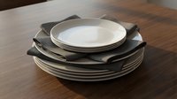 Stacked dinnerware set with white and black plates arranged on wooden table surface, suitable for tableware design and dining concepts.