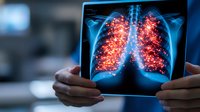 Medical professional examining chest x-ray showing glowing red lung inflammation on digital tablet display, highlighting respiratory condition visualization.