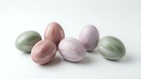 Pastel marble Easter eggs in soft pink green and lavender colors arranged on white background for spring holiday decorations and seasonal crafts.