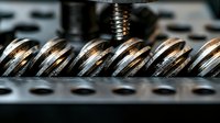 Close-up macro shot of industrial metal gears and mechanical components showing precise engineering details with selective focus on metallic surfaces.