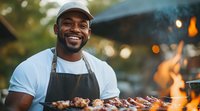 Cheerful African American male chef grilling meat outdoors at barbecue party, wearing apron and cap, with bokeh lights and flames in background.