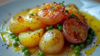 Roasted baby potatoes and green peas in butter sauce garnished with herbs and spices, macro food photography with selective focus on golden crispy surface.