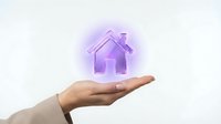 Unrecognizable person holding glowing purple house icon above open palm against white background, representing real estate, property investment, and smart home technology.