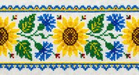 Traditional Ukrainian cross-stitch embroidery pattern with sunflowers and blue cornflowers on white fabric, featuring geometric border design for textile crafts.