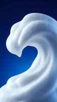 White creamy swirl flowing against deep blue background creating smooth organic curves and waves for cosmetic skincare product design.
