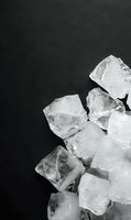 Fresh ice cubes scattered on dark slate surface for beverage cooling and food presentation in restaurants and bars.