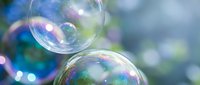 Colorful soap bubbles floating in air with rainbow reflections against soft blurred background creating dreamy atmosphere for relaxation and joy concepts.
