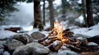 Cozy campfire burning in snowy winter forest with flames illuminating surrounding pine trees and rocks, creating warm atmosphere in cold wilderness.