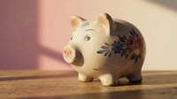 Ceramic piggy bank with floral pattern on wooden surface for savings and financial planning concepts.