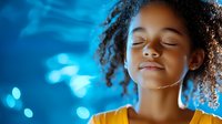 Young African American woman with curly hair and closed eyes enjoying peaceful moment against blue bokeh background, expressing serenity and mindfulness.