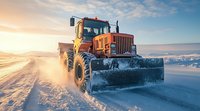 Orange snow plow truck clearing snowy winter road during golden sunset with dramatic sky and sunbeams shining through clouds in cold weather.
