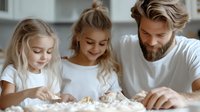 Caucasian father and two young daughters making dough together in bright kitchen, family baking activity with flour on wooden table, joyful weekend cooking.