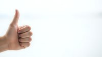 Hand showing thumbs up gesture on white background for positive feedback and approval concepts.