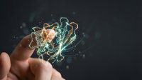 Hand holding glowing digital brain with electric neural connections and sparks on dark background representing artificial intelligence and innovation.