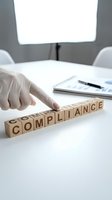 Businesswoman in white gloves arranging wooden blocks spelling compliance on desk under bright overhead lighting in modern office setting for regulatory standards.