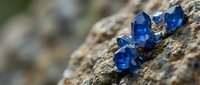 Blue sapphire crystals embedded in natural rock formation displaying raw gemstone mineral specimens for geology education and jewelry making.