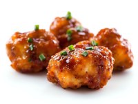 Glazed chicken meatballs garnished with fresh chopped herbs on white background, close-up view showing caramelized coating and juicy texture for food service and menu design.