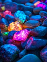 Colorful glowing stones with neon lights creating magical illuminated pebbles for meditation, spa decoration, fantasy landscapes and mystical design projects.