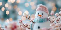 Cheerful snowman with pink knit hat and blue scarf surrounded by cotton branches against blurred bokeh winter background.
