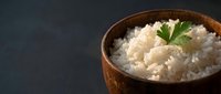 Steamed white rice in wooden bowl garnished with fresh parsley on dark background for healthy meal preparation and Asian cuisine cooking concepts.