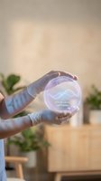 Hand wearing white latex gloves holding glowing crystal ball displaying stress level optimal with wave graph, wellness technology concept for mental health monitoring and biometric analysis.