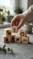 Hand placing wooden blocks with eco-friendly symbols including solar panels, wind turbine, recycling, water drop, leaves and bicycle on table.