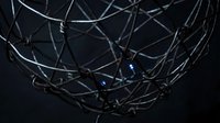 Tangled metal wire mesh with blue light reflections creating abstract industrial pattern on dark background for modern design projects.