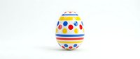Colorful Easter egg with geometric patterns and polka dots isolated on white background for holiday decorations and spring celebrations.