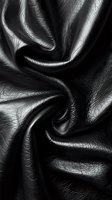 Dramatic black leather texture with deep folds and wrinkles creating abstract patterns. Luxurious material surface with glossy highlights and shadows for fashion design.