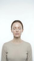Woman with closed eyes wearing beige sweater, isolated on white background, suitable for wellness, mindfulness, meditation, mental health, and relaxation concepts.