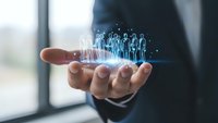 Business professional holding holographic team icons in palm representing human resources management and digital workforce solutions.
