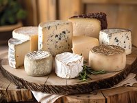 Gourmet cheese board with variety of artisanal cheeses including blue, brie, and aged hard cheeses arranged on rustic wooden platter for entertaining.