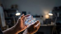 Hands holding glowing transparent sphere with swirling energy patterns in modern interior space for technology and innovation concepts.