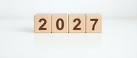 Wooden blocks displaying 2027 numbers arranged in row on white background for New Year planning and future goals concept.