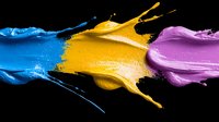 Vibrant paint splashes in blue, yellow and purple colors colliding and creating dynamic motion effect on black background, artistic liquid paint photography.