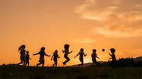Silhouettes of diverse children holding hands and jumping together outdoors during golden hour sunset, representing friendship, unity, and outdoor play for family and community concepts.