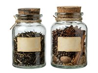 Apothecary glass jars with cork stoppers containing dried herbs and spices with blank labels, isolated on white background for culinary, wellness, and storage design projects.