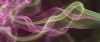 Flowing colorful smoke waves in pink and green hues creating elegant abstract patterns on dark background for modern design projects.