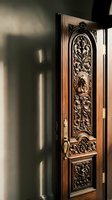 Ornate wooden door with intricate carved floral patterns and decorative metalwork in elegant interior hallway with dramatic natural lighting and shadows.