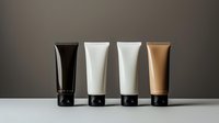 Minimalist cosmetic tubes in black, white and beige colors arranged in row on neutral background. Clean modern packaging design for beauty products.