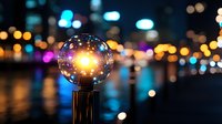 Glowing light bulb with warm filament against blurred colorful city lights at night creating magical bokeh effect for creative concepts and innovation themes.