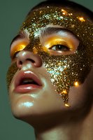Young woman with golden glitter face mask and luminous makeup creating sparkly beauty portrait for skincare and cosmetic advertising campaigns.