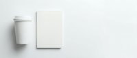 Blank white coffee cup with lid and empty notebook on neutral background, isolated mockup for branding, packaging design, and marketing materials.